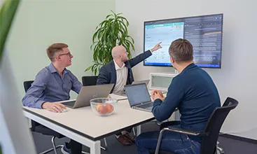 This is a photo of three individuals who are in the middle of a hackathon run by the AI Competence Centre, where interdisciplinary Geberit teams develop AI agents. (Photo)